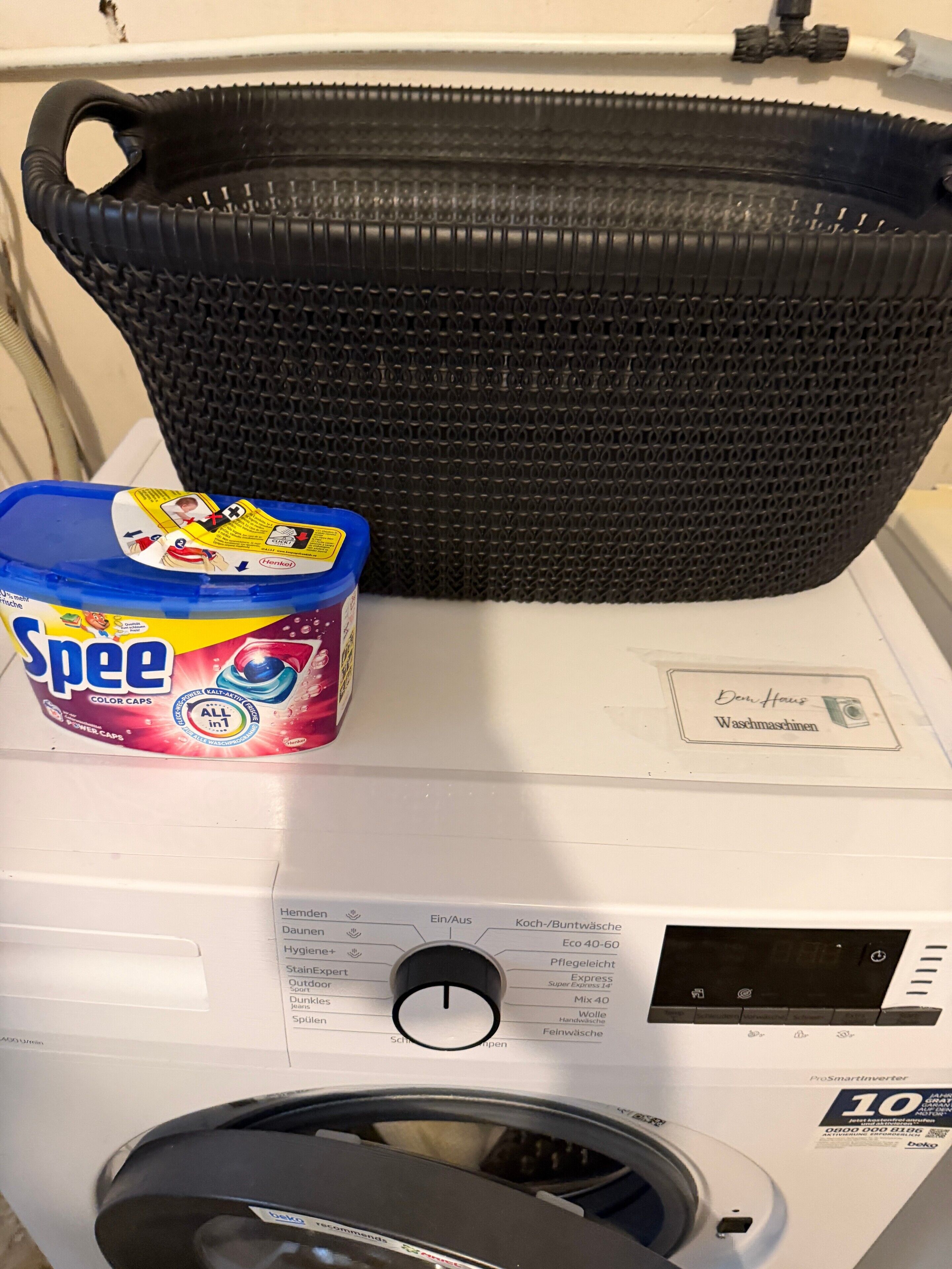 A washing machine with a basket, a detergent container, and a label indicating 'Washing Machines.'