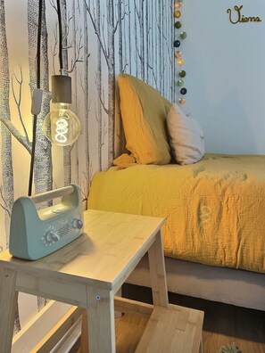 A room with a bed, a table with a lamp, and a wall with a tree pattern. - "Le clos du bon temps" (Lugny)