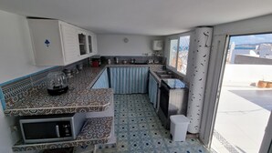 A compact kitchen with a microwave, sink, and a small trash bin. - Tangier medina Riad Sea view and Spain (Tanger)