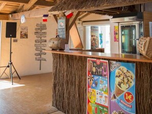 A rustic interior with a wooden counter, a vintage radio, and a poster advertising ice cream. - Cozy mobile home - 6 guests (Saint-Hilaire-de-Riez)