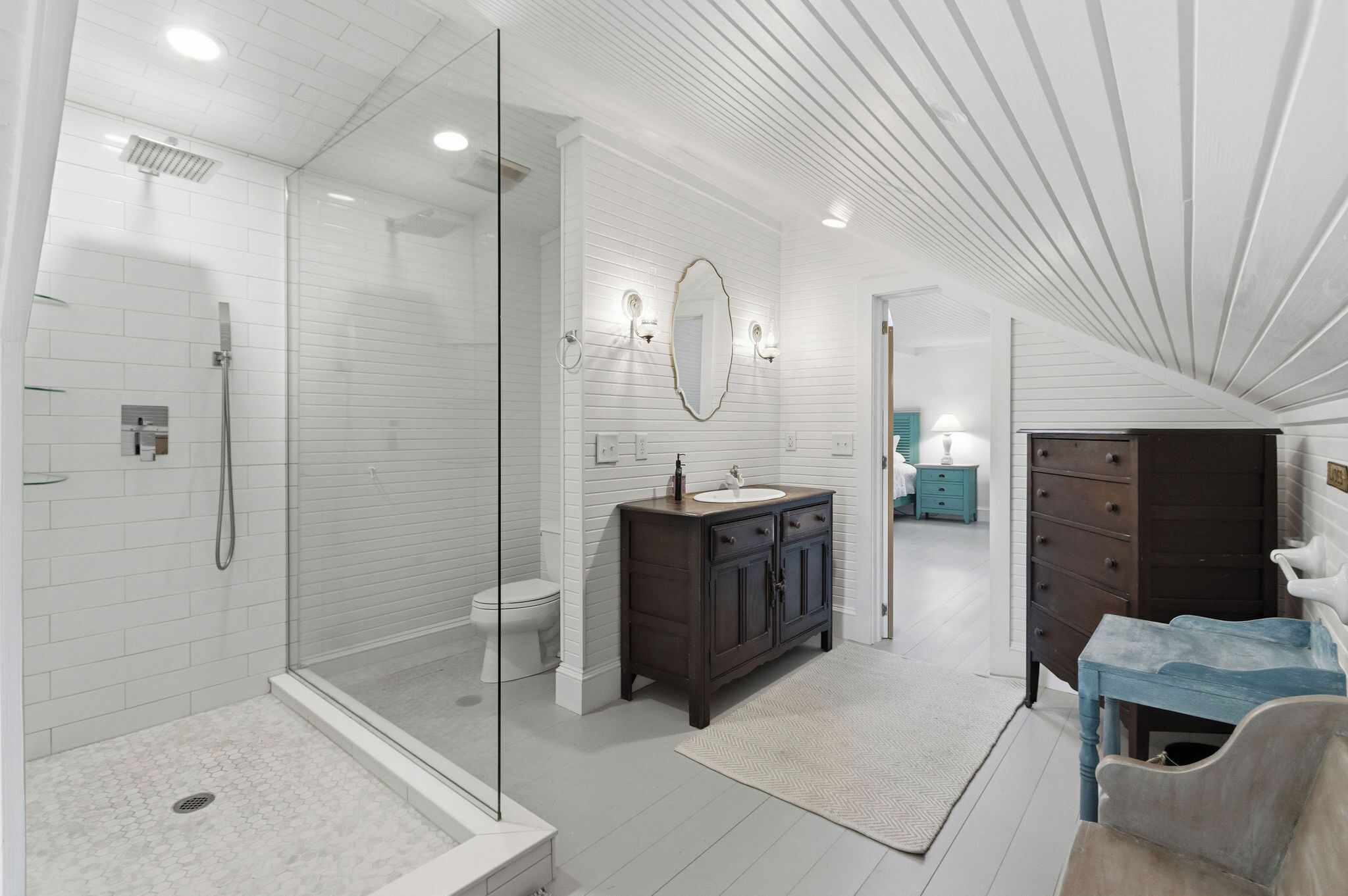 Une salle de bain moderne avec une douche à parois de verre, un meuble-lavabo en bois foncé et un sol carrelé de couleur blanche.