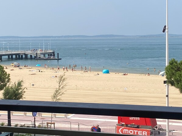 A beach with people, a pier, and a 'MOTER' sign. - Studio sea view - 2 guests (Arcachon)