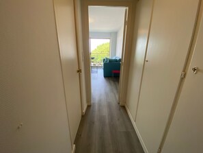 A hallway leading to a living area with a view of greenery outside. - Studio sea view - 2 guests (Arcachon)