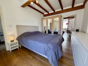 Une chambre à coucher avec un lit, une table de chevet et un miroir.