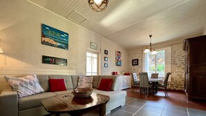 Ein Wohnzimmer mit einer Couch, einem Couchtisch und einem Essbereich mit Stühlen und einem Tisch.
