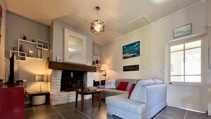 Ein Wohnzimmer mit Kamin, einer Couch, einem Couchtisch und einem Fernseher.