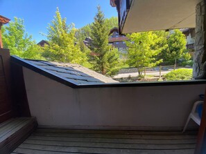 Ein Balkon mit Blick auf ein Wohngebiet, eine Steinmauer und ein Holzterrasse.