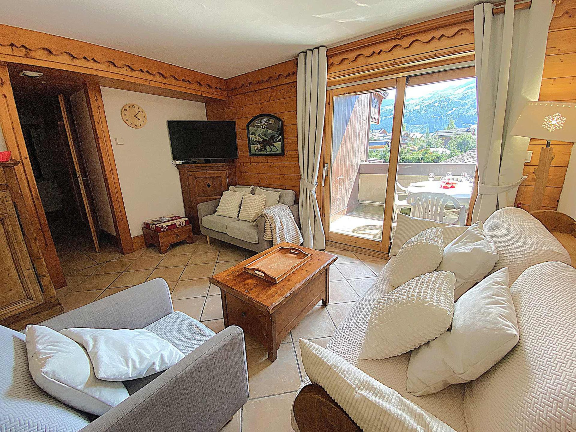 A cozy living room with a sofa, armchair, wooden coffee table, and a television.