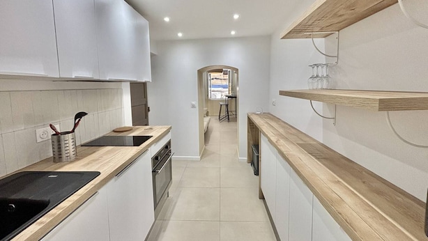 A modern kitchen with white cabinets, a wooden countertop, and a built-in oven. - Apartment with air conditioning, central Ajaccio (Ajaccio)