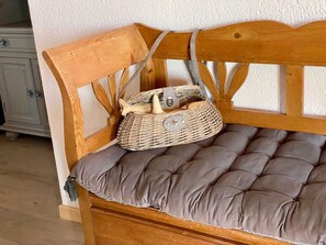 A wooden bench with a cushioned seat and a woven basket placed on it. - Unique house, pond view - 4 guests (Mèze)