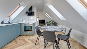 Una cocina moderna con comedor, tragaluces y horno empotrado.