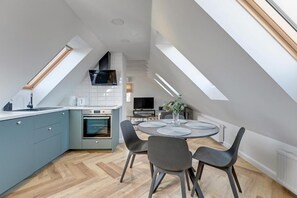 Una cocina moderna con comedor, tragaluces y horno empotrado.