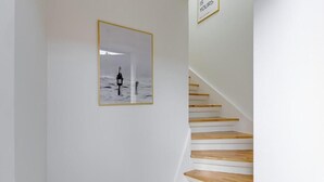 Una escalera con escalones de madera y un cuadro en la pared.