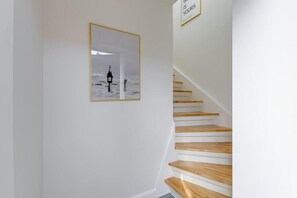 Una escalera con escalones de madera y un cuadro en la pared.
