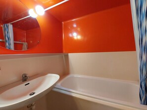 Ein Badezimmer mit Waschbecken, Spiegel und Badewanne.