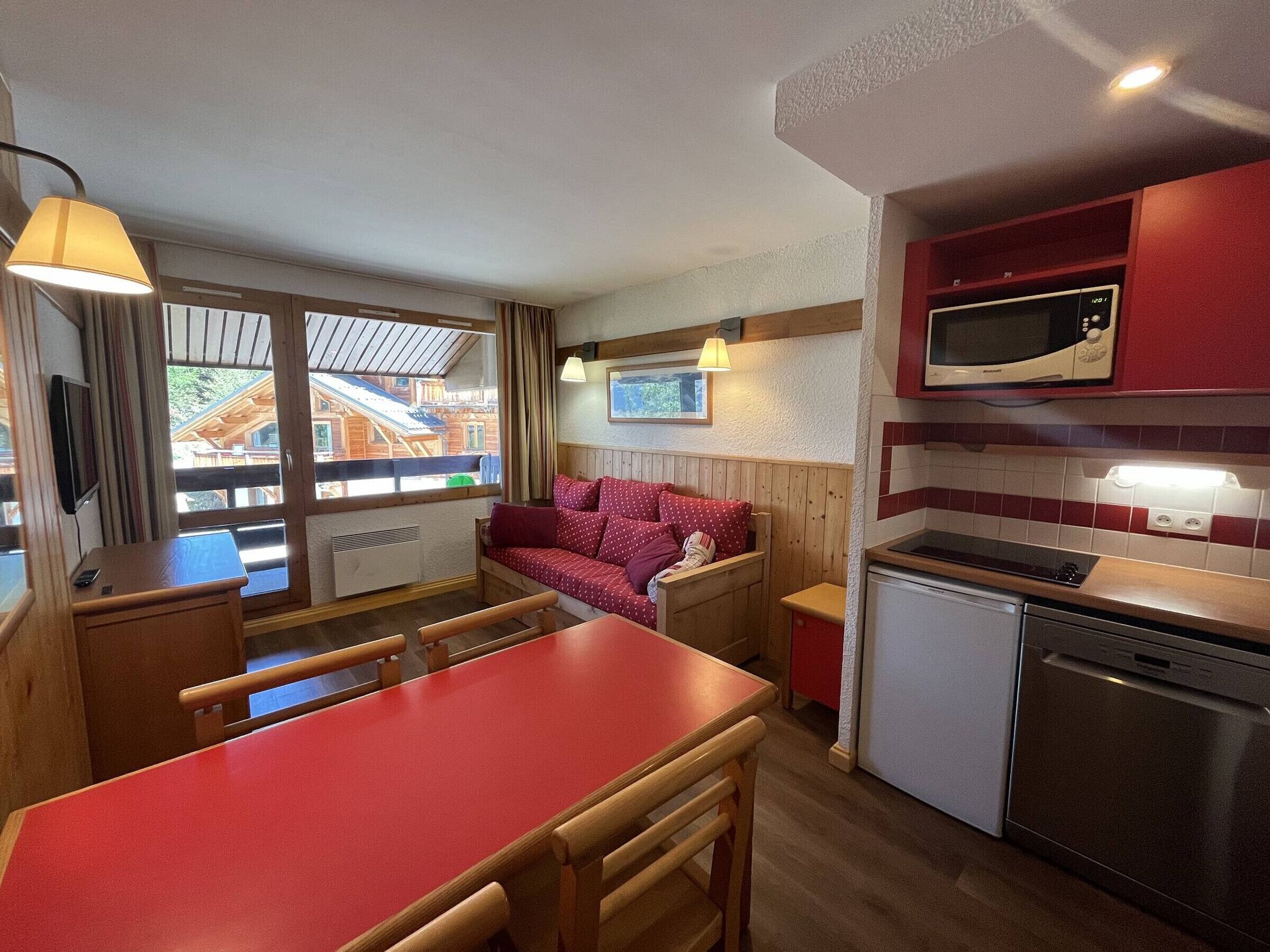 A compact kitchen with a dining area, a microwave, and a small refrigerator.
