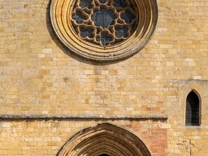A building with a circular stained glass window and a pointed arch doorway.