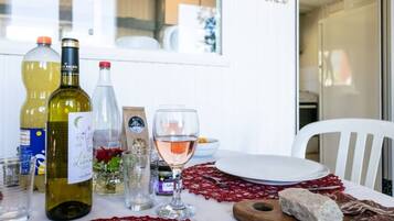 A dining table set with wine bottles, glasses, and a plate with food.