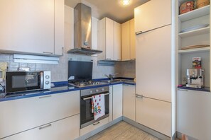 Eine moderne Küche mit Mikrowelle, Herd, Backofen und Kaffeemaschine.