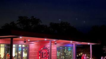 Een restaurant met een rode gevel, glazen deuren en een groot verlicht nummer '12' bord.
