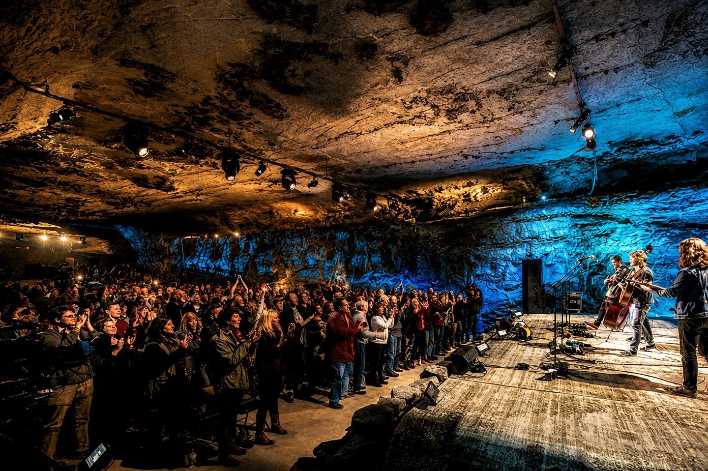 Un concierto en una cueva con un público mirando hacia un escenario.