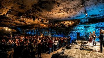 Un concierto en una cueva con un público mirando hacia un escenario.