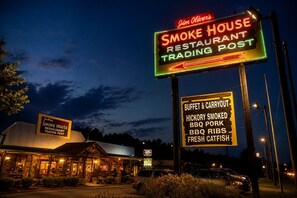 Un restaurant reconnaissable à son enseigne au néon indiquant qu’il s’agit d’un fumoir et d’un point de vente, proposant un buffet et des plats à emporter, ainsi que des spécialités barbecue fumées au bois de noyer, des travers de porc et du poisson-chat frais.