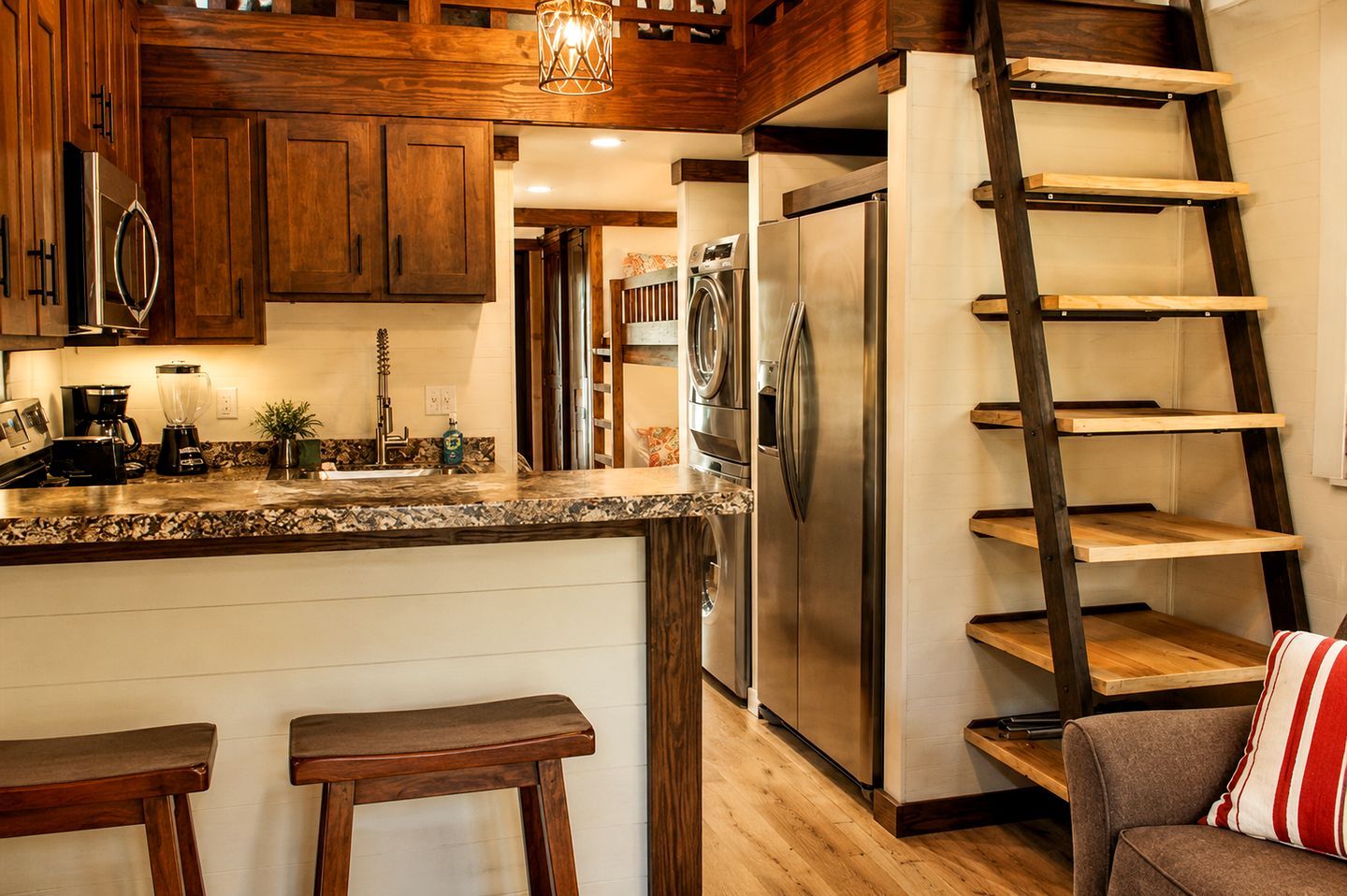 A kitchen with wooden cabinets, a stainless steel refrigerator, a coffee maker, and a ladder shelf.