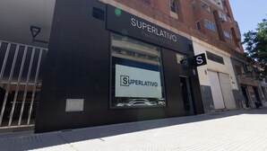 A building with a sign for 'Superlativo FlexStay Hotel' and a closed garage door. - Hostel Superlativo Vialia I (Málaga)