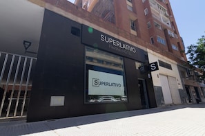 Un bâtiment avec une enseigne indiquant « Superlativo FlexStay Hotel » et une porte de garage fermée.