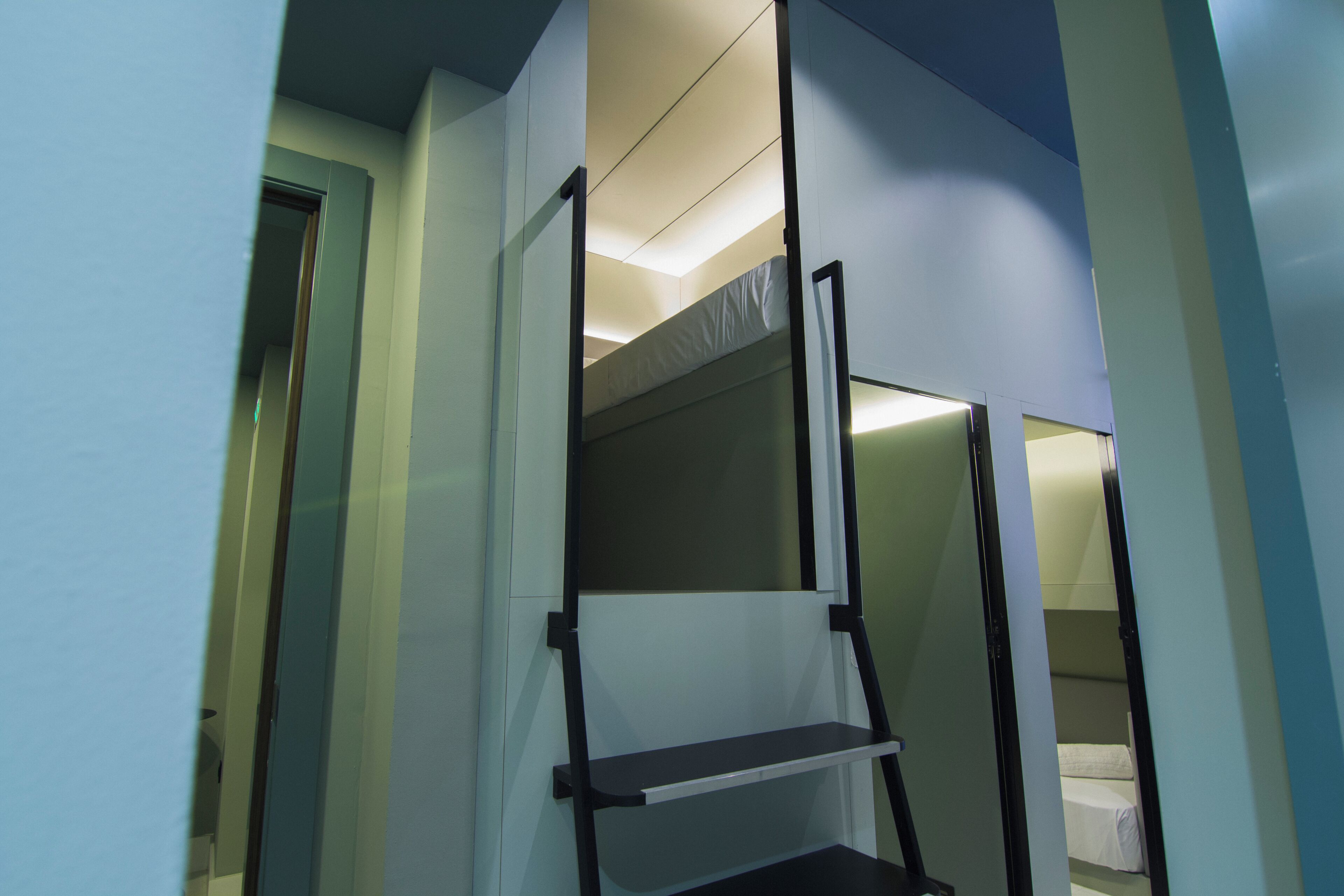 A narrow hallway with a bunk bed and a small shelf.