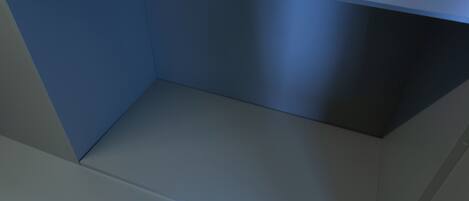 A room with a blue wall, a grey floor, and a white ceiling.