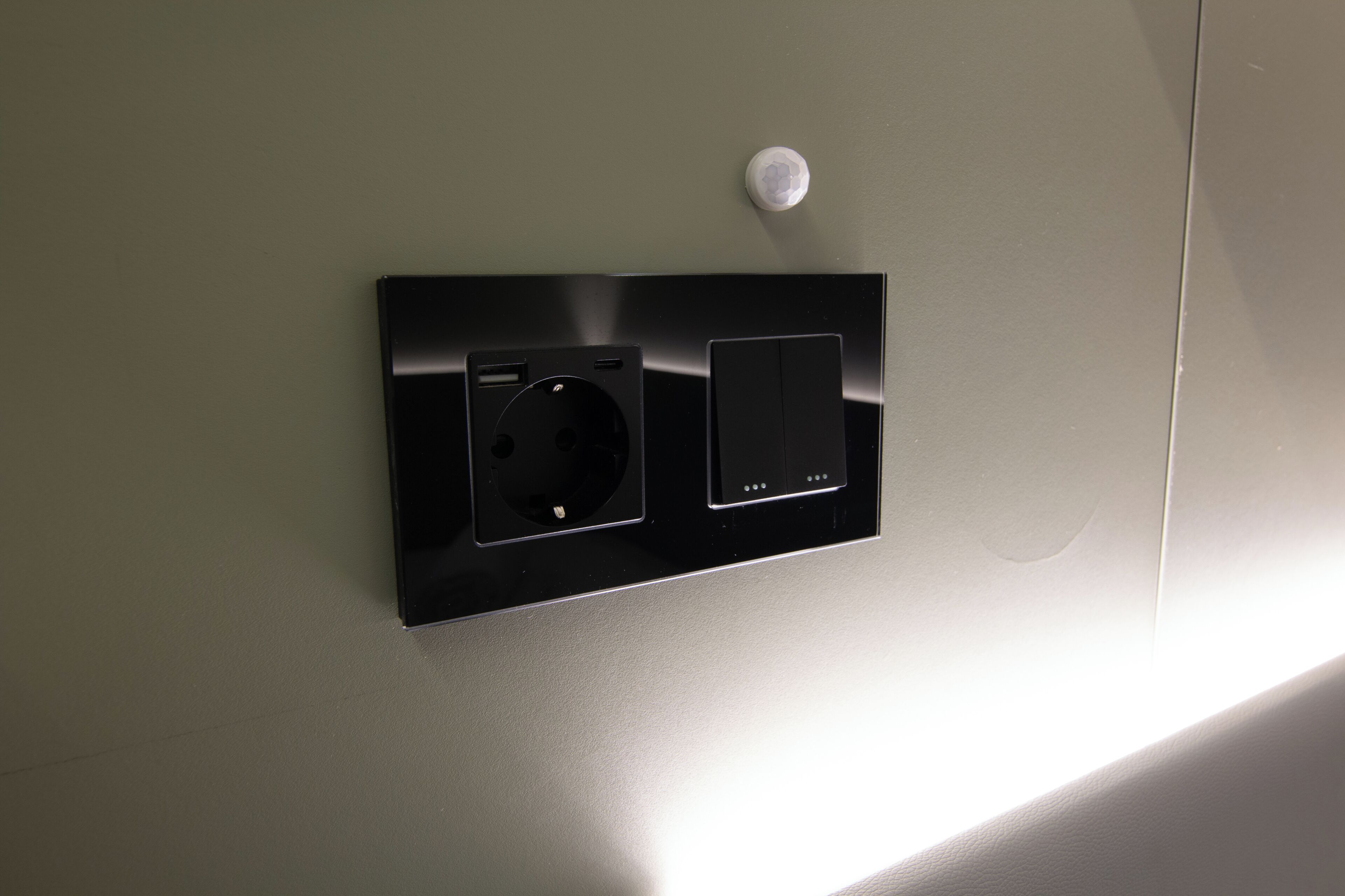Toma de corriente con interruptor y enchufe, montada en la pared.