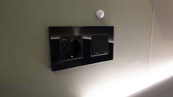 Toma de corriente con interruptor y enchufe, montada en la pared.