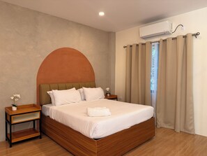 Quarto com cama de madeira, mesa de cabeceira, ar-condicionado na parede e janela com cortinas.