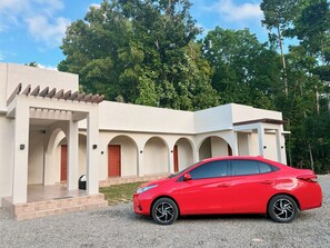 Um edifício moderno com um carro vermelho estacionado na frente.