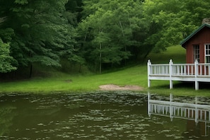 A wooden dock extending over a calm lake, surrounded by dense green trees. - Romantic and Secluded Log Cabin with Private Hot Tub in Eureka Springs, Arkansas (Eureka Springs)