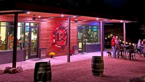 A restaurant with a red exterior, glass doors, and a large illuminated number '12' sign. - Idyllic Tented Cabin Incredible for Adventure Lovers in Texas (Johnson City)