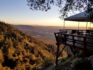 A wooden deck with outdoor seating overlooking a mountainous landscape. - Rustic Mountain Lodge with Ocean Views near Palomar Observatory, Palomar Mountain CA (Palomar Mountain)