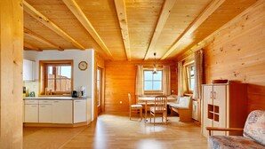 Un interno in legno con cucina, zona pranzo e divano.
