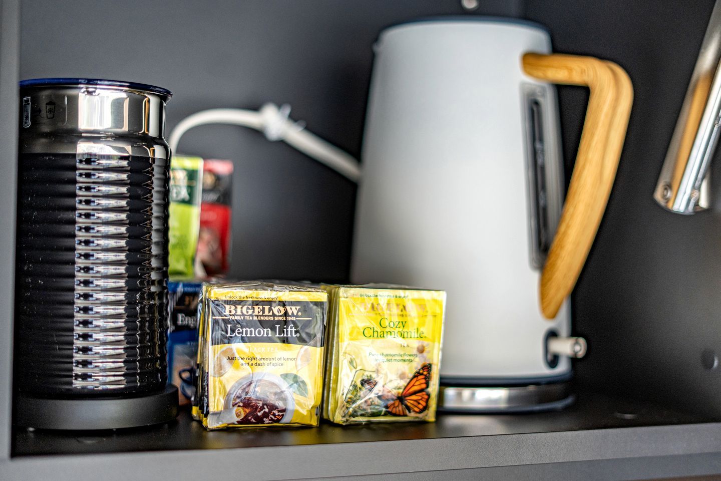 A kitchen with a kettle, a coffee maker, and tea bags.