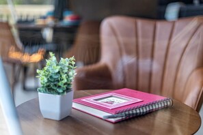 Una mesa con una planta en maceta y un cuaderno.