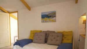 Une chambre à coucher avec un lit, un tableau au mur et une porte.