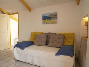 Un dormitorio con una cama, un cuadro en la pared y una puerta.