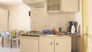 Une cuisine équipée d’un lave-vaisselle, d’une machine à café et d’un égouttoir bleu.