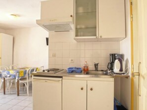 Una cocina con lavavajillas, cafetera y escurreplatos azul.