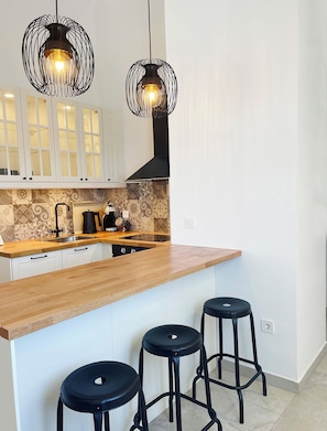 A kitchen with a wooden countertop, a sink, a kettle, and two black stools. - Relaxation with a view and close to the beach, Zaostrog VistaBlu (Zaostrog)