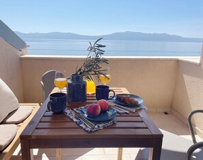 A table with breakfast items, a plant, and a view of the sea. - Relaxation with a view and close to the beach, Zaostrog VistaBlu (Zaostrog)