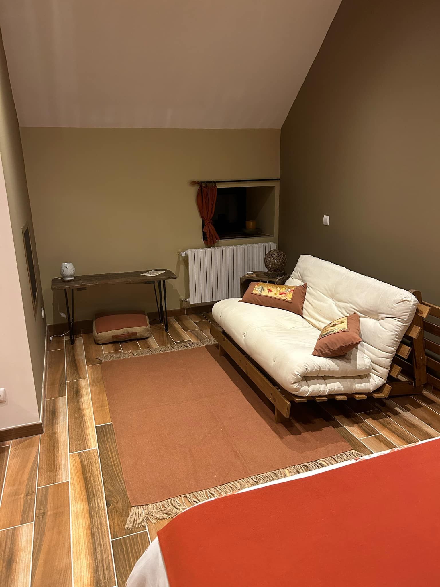 Une petite pièce agréable, avec un lit simple, une petite table et un radiateur.