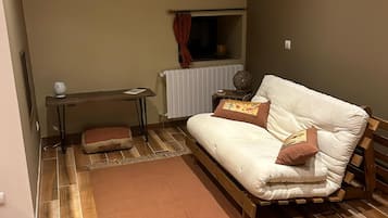 Une petite pièce agréable, avec un lit simple, une petite table et un radiateur.